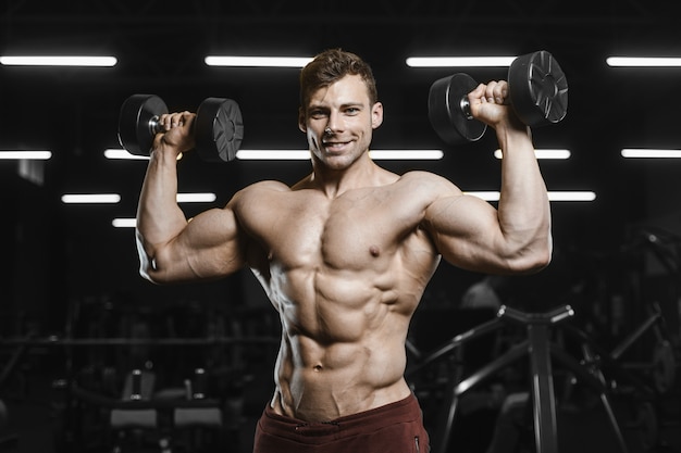 Beaux hommes athlétiques forts pompage des muscles musculation d'entraînement