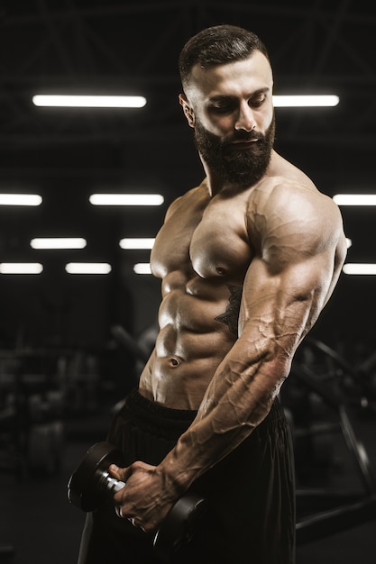 Beaux hommes athlétiques forts pompage des muscles séance d'entraînement concept de musculation