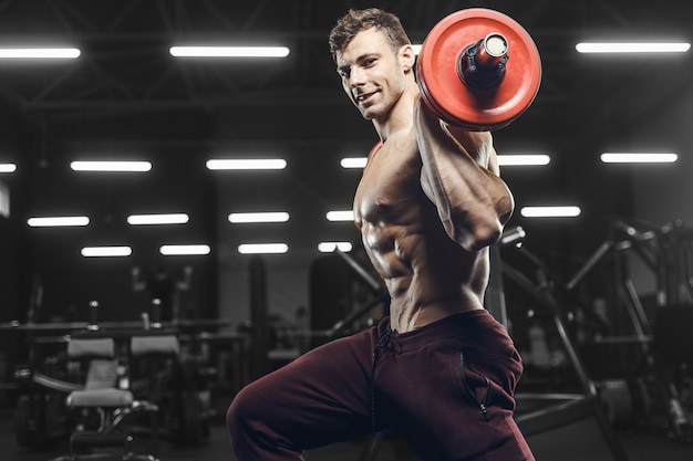 Beaux hommes athlétiques forts pompage des muscles séance d'entraînement haltères squat concept de musculation