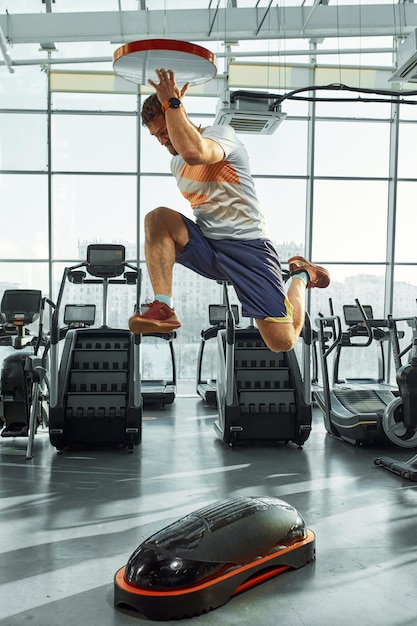 De beaux hommes musclés s'entraînent sur une plate-forme souple d'entraînement fonctionnel sur fond de salle de sport