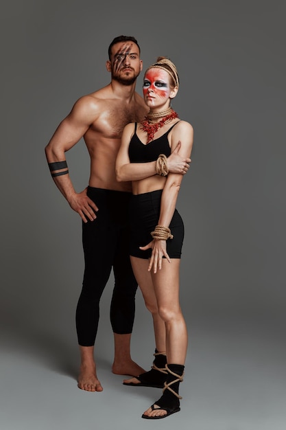 Beaux jeunes acrobates ou gymnastes avec maquillage coloré sur fond dégradé bleu rose Couple de ballet professionnel dansant Duo émotionnel exécutant l'art chorégraphique Instinct animal
