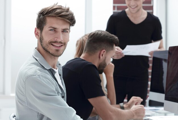 De beaux jeunes hommes portant assis avec certains de ses collègues dans une salle de réunion