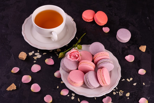 Beaux macarons roses savoureux sur un fond de béton