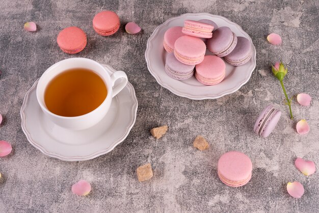 Beaux macarons roses savoureux sur un fond de béton