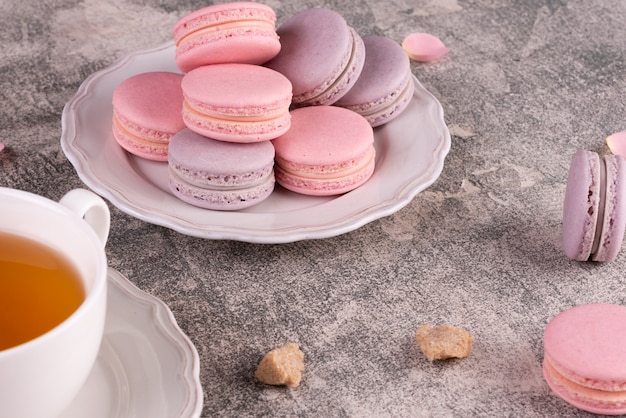 Beaux macarons roses savoureux sur un fond de béton