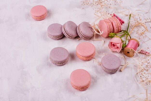 Beaux macarons roses savoureux sur un fond de béton