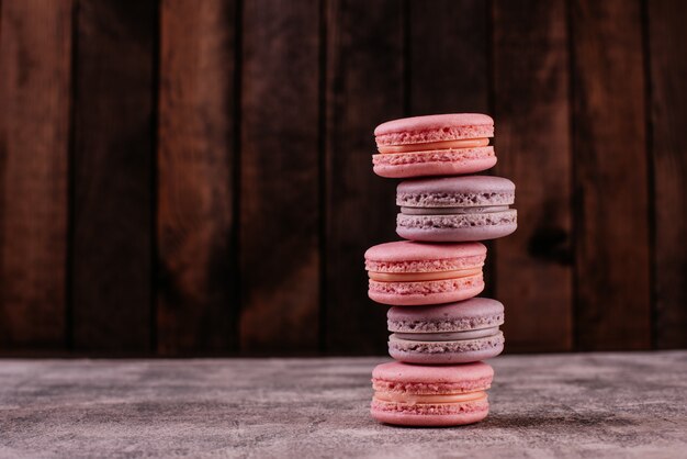 Beaux macarons roses savoureux sur un fond de béton