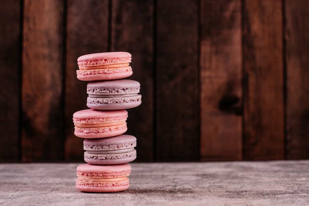 Beaux macarons roses savoureux sur un fond de béton