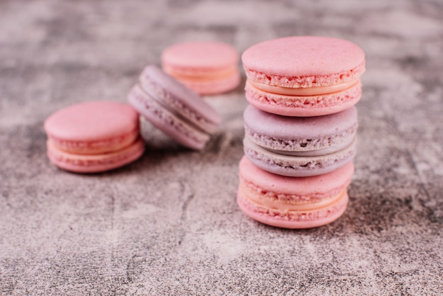 Beaux macarons roses savoureux sur un fond de béton