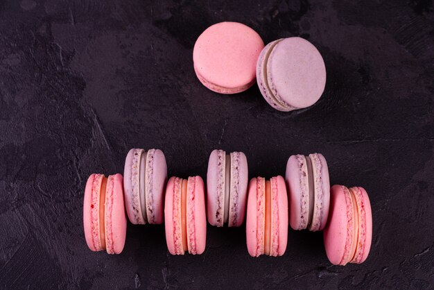 Beaux macarons roses savoureux sur un fond de béton