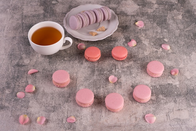 Beaux macarons roses savoureux sur un fond de béton