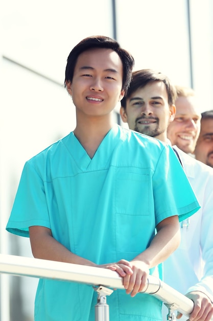 Beaux médecins souriants debout près de la clinique