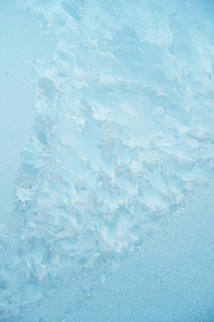 Photo de beaux motifs glaciaux sur une fenêtre bleue