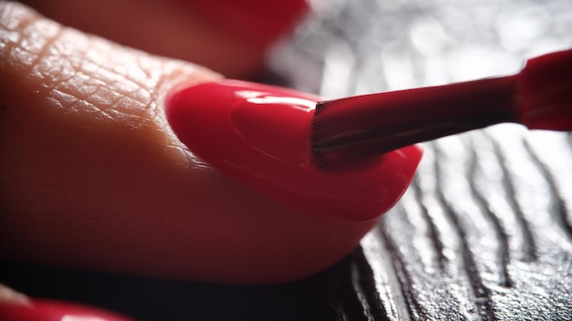 Beaux ongles féminins manucurés avec vernis à ongles rouge