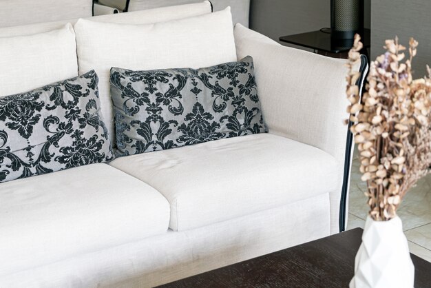 Photo beaux oreillers sur canapé et vase avec des fleurs sèches