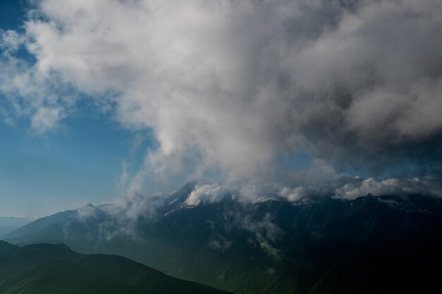 Photo beaux paysages de montagne nuages au-dessus des sommets des montagnes jour ensoleillé