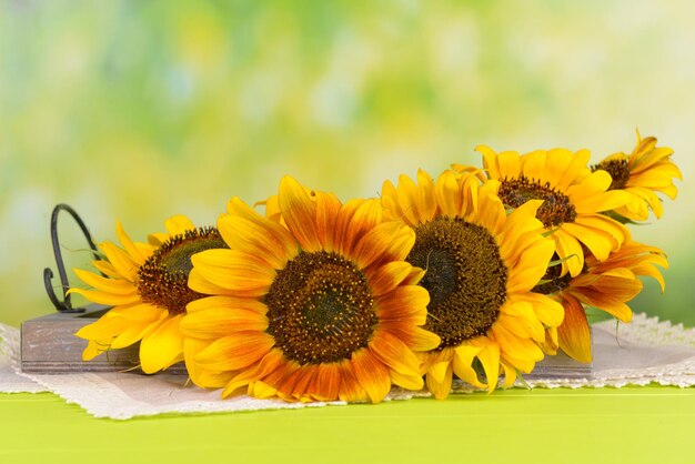 Beaux tournesols en pichet sur serviette sur table sur fond clair