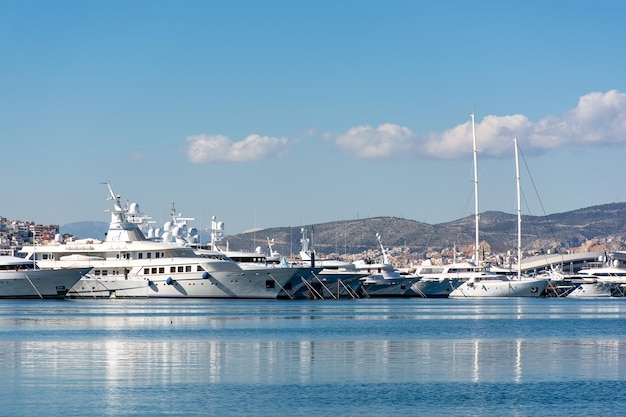 Beaux yachts sur la jetée contre le ciel bleu Quai d'Athènes