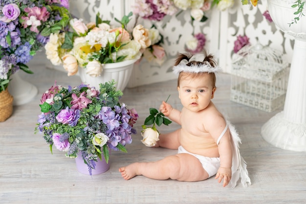 Bébé avec des ailes d'ange parmi les fleurs, le concept de la Saint-Valentin,