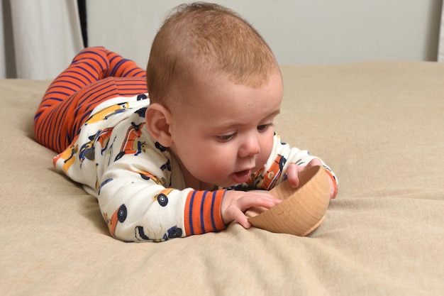 Bébé allongé sur le lit jouant avec un jouet.