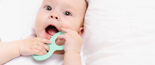 Photo un bébé avec un anneau de dentition sur un fond blanc teething children's article