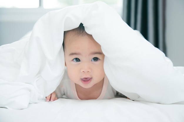 Bébé asiatique allongé sur le lit avec une couverture douce à l'intérieur mignon petit nouveau-né asiatique