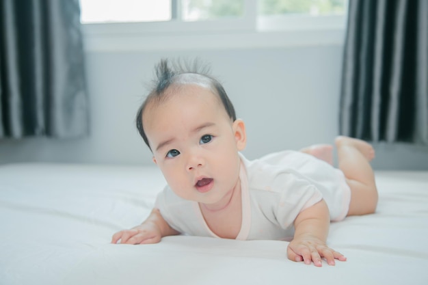 Bébé asiatique allongé sur le lit avec une couverture douce à l'intérieur mignon petit nouveau-né asiatique