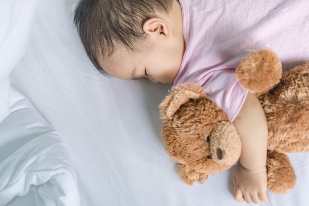 Bébé asiatique dormant sur le lit