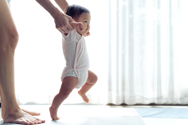 Un bébé asiatique fait ses premiers pas sur le tapis