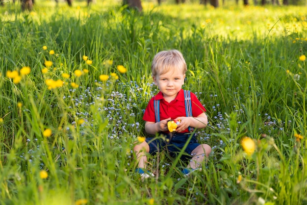 Bébé assis sur l'herbe avec un jouet dans ses mains