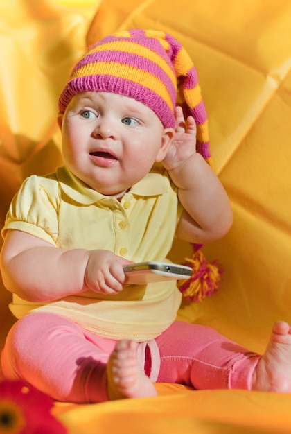 Photo bébé au chapeau avec téléphone écoute