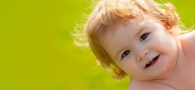 Bébé sur le champ d'herbe de printemps bannière caucasien bébé enfant portrait gros plan visage d'enfants