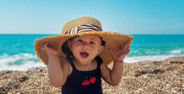 Bébé avec un chapeau sur la plage. Mise au point sélective.