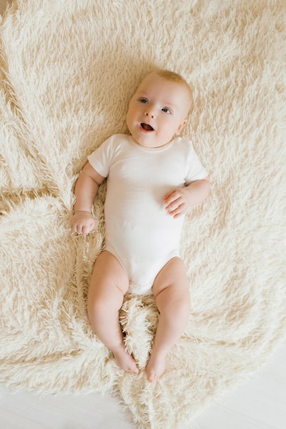 Un bébé de cinq mois est allongé sur une couverture légère dans la chambre Vue de dessus d'un charmant garçon