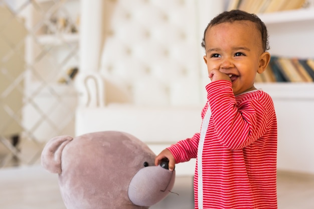 Un bébé curieux et mignon étudie des choses dans la pièce.