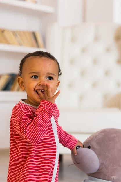 Un bébé curieux et mignon étudie des choses dans la pièce.