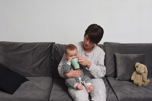 Le bébé curieux regarde dans la tasse