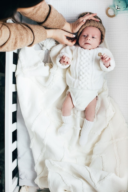 Bébé dans un berceau les bras de la mère étreignent la tête du bébé