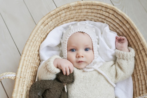 Bébé dans un berceau en osier avec jouet en bois Fête des mères Journée de la protection des enfants Enfant joyeux enfance heureuse