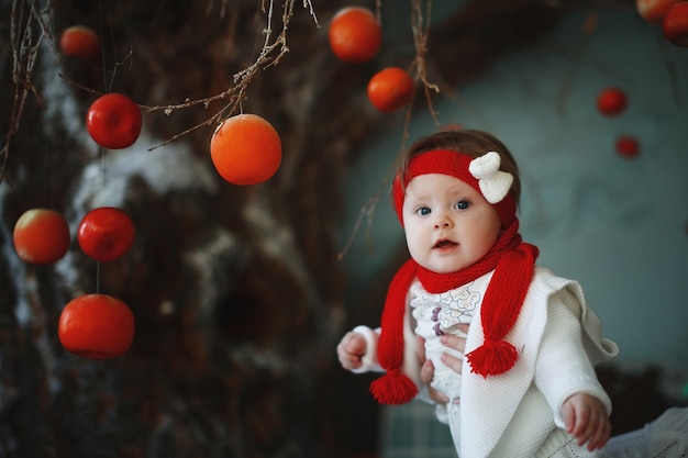 Un bébé dans un bonnet rouge avec des boules à l'intérieur du nouvel an.