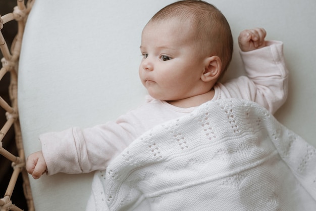 bébé dans une chambre ensoleillée blanche nouveau-né se repose dans son lit