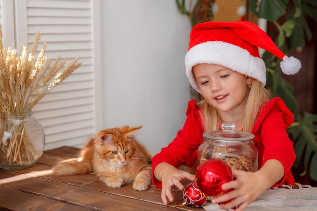 Un bébé dans un costume de père Noël sur fond blanc