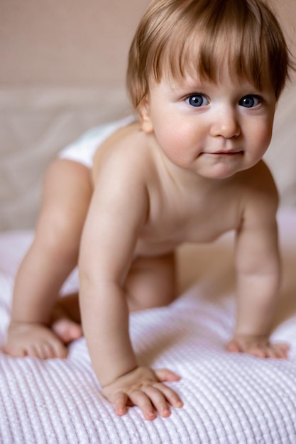 Un bébé dans une couche sur une couverture rayée