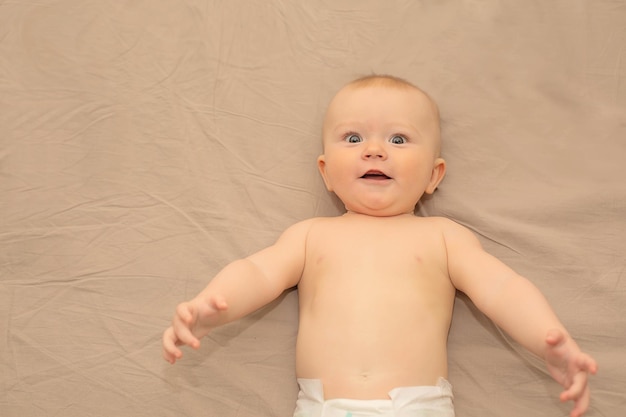 Un bébé dans une couche regarde la caméra.