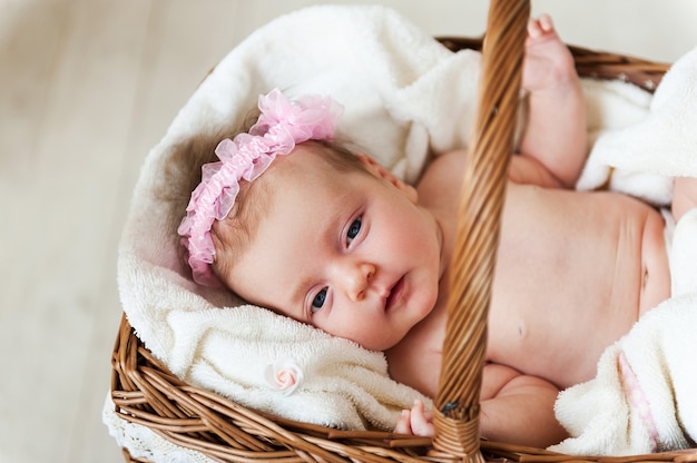 Bébé dans un panier. Vue de dessus du petit bébé allongé dans un panier en osier et recouvert d'une serviette