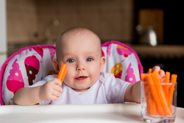 bébé dans un siège enfant manger des légumes