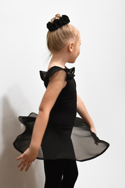 Photo bébé danseur de ballet en position en uniforme noir