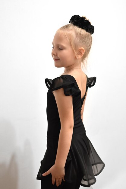 Bébé danseur de ballet en position en uniforme noir