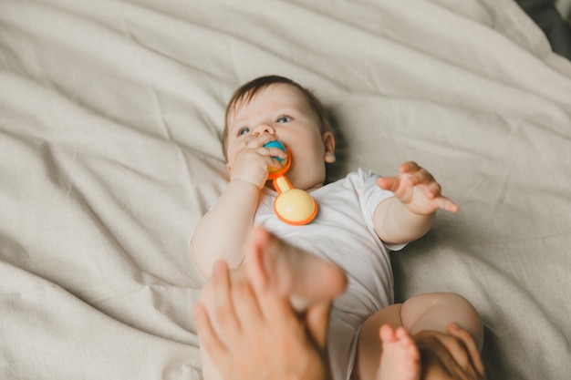 Un bébé avec une dentelle et un sonnerre sur un lit de coton Teething Espace de copie d'article pour enfants