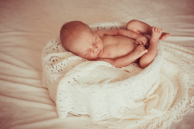 Bébé dort nue sur un lit